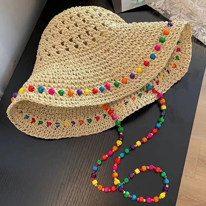 Chapeau seau en polyester tressé beige, Modèle Crochet Perles; bordure perlée colorée, collier multicolore posé à côté