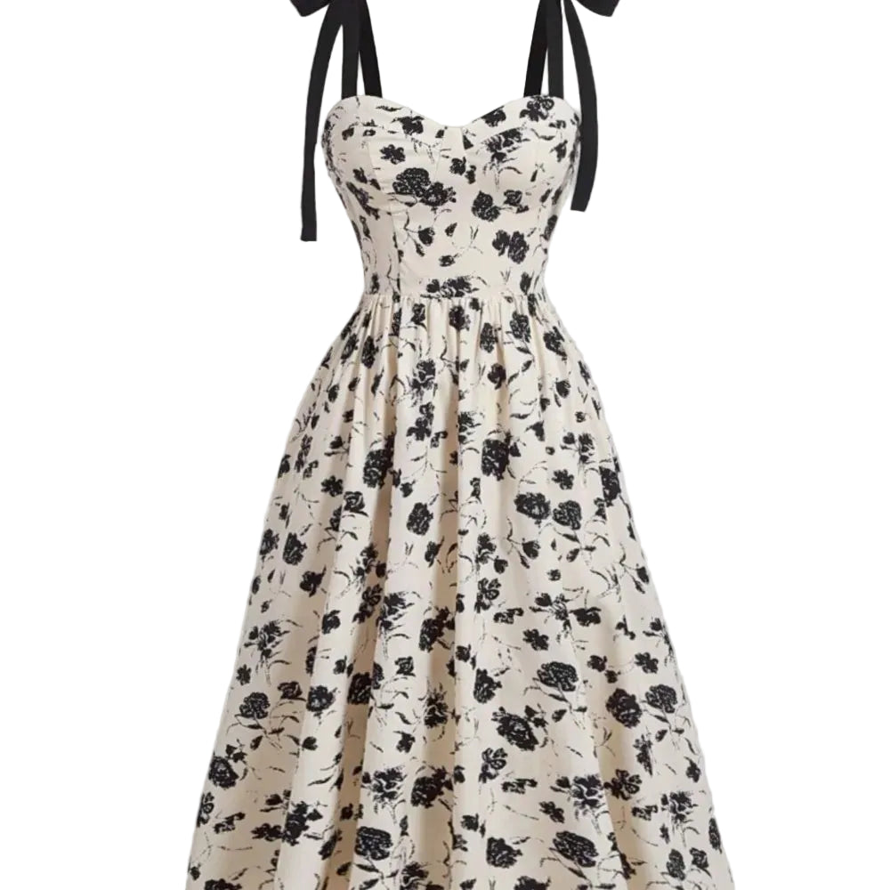 Robe mi-mollet à bretelles fines, imprimé floral noir sur crème, silhouette évasée.