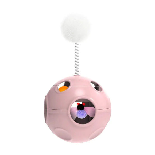 Jouet interactif pour chats, balle rose à trous avec pompon blanc sur ressort, petit jouet violet visible.