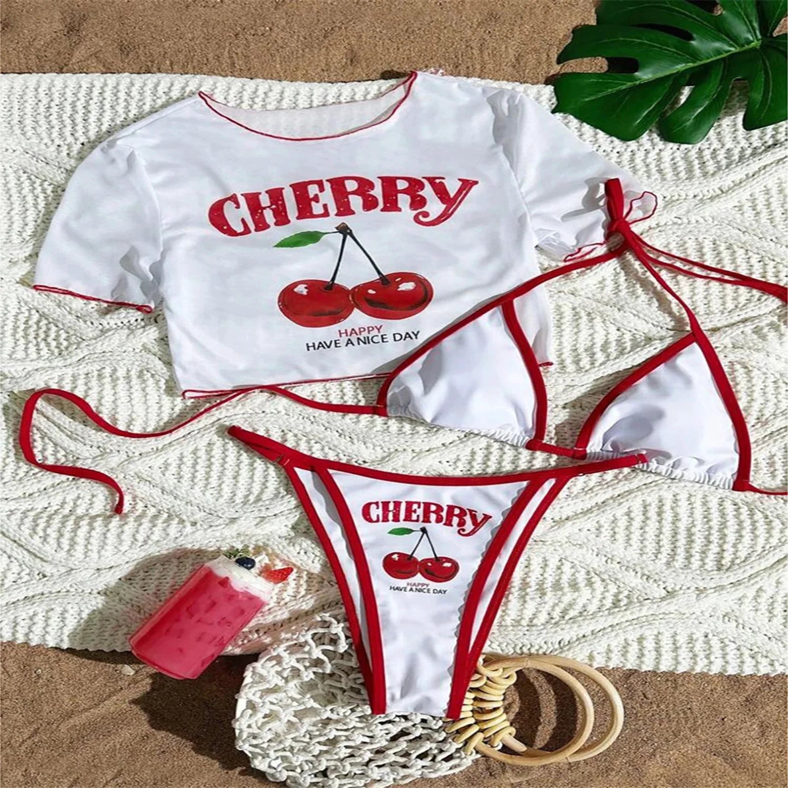 Ensemble bikini trois pièces blanc et rouge à imprimé cerises, t-shirt imprimé cerises et bikini à cordons rouges