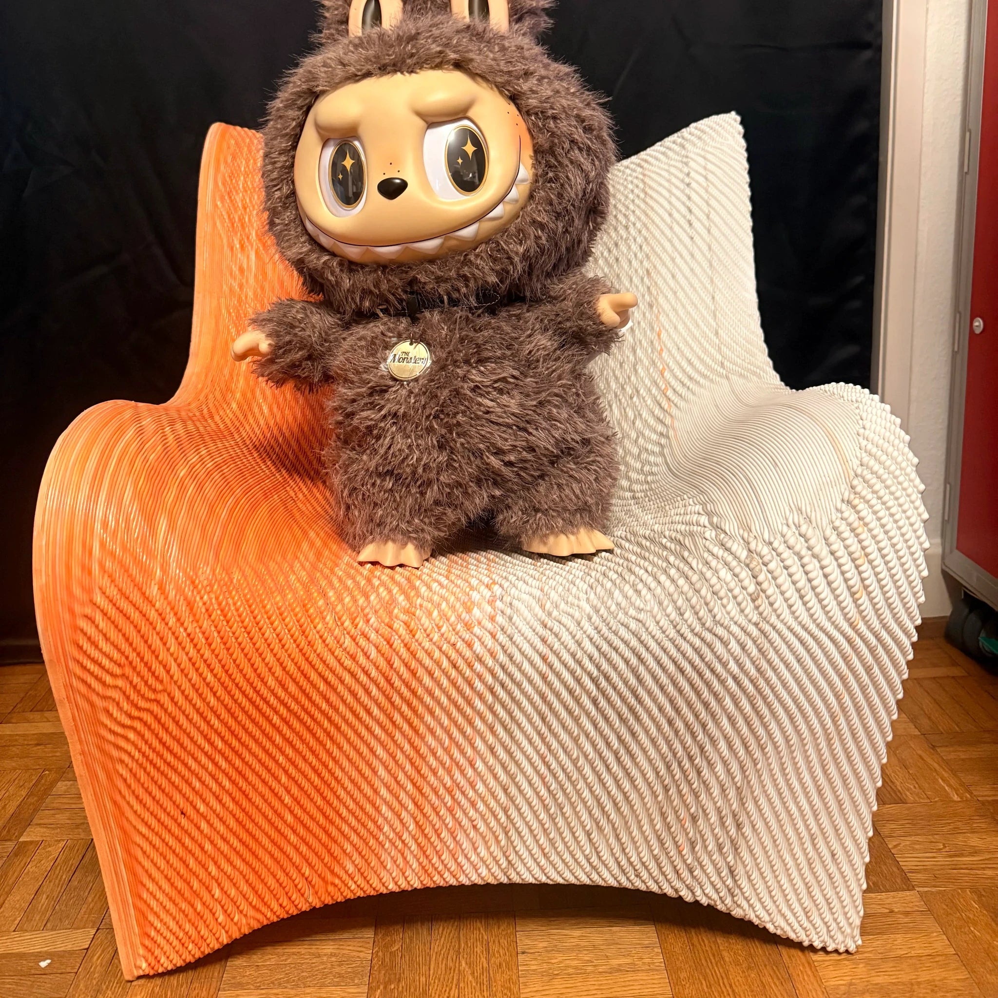 Fauteuil design Kesk, bicolore orange et blanc en plastique, peluche brune posée dessus